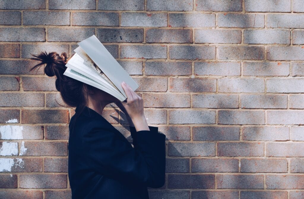 girl with book on her face